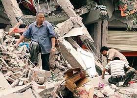 A rescuer searches the rubble of the collapsed Juyuan middle school where six children died in Dujiangyan, in southwest China Sichuan province.