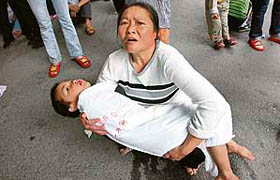 A Chinese woman tries to evacuate her son from a hospital in Chongqing on Monday after an earthquake measuring 7.8 rocked the neighbouring Sichuan province.
