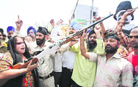 Activists of the Nirbhow Nirvair, a Sikh non-government organisation, holds up a mock rifle, shouting anti-Pak slogans during the Jammu bandh on Monday.