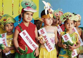 Students of Chanda Mama Play Way School take part in a fruit-modeling day in Ludhiana on Monday.