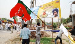  BJP activists tearing posters of SAD chief Sukhbir Badal in Bathinda on Tuesday. Tribune photo: Kulbir Beera