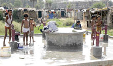 Children draw water through hand pumps from an underground water tank in a slum in Chandigarh.
