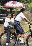 A schoolboy covers himself and his sister with an umbrella following rain in Chandigarh on Tuesday.
