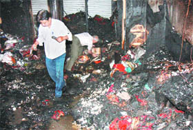 Shop owners search for the remains after a fire broke out at a saree shop at Chandni Chowk in the Capital on Tuesday.