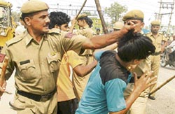 The police roughs up a person protesting against a demolition drive in Faridabad