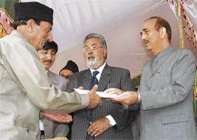 Chief Minister Ghulam Nabi Azad hands over the ownership rights of agricultural land to a farmer in Badgam