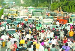 Senior Congress leaders Gurkanwal Kaur and Kanwaljit Singh Lali along with party workers stage a dharna on the national highway in Jalandhar.