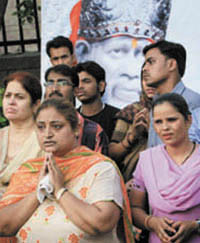 Devotees wait outside the Sai Baba Mandir at Lodhi Road in the Capital, which received a hoax call on Thursday.