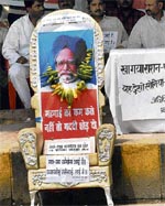 BJP workers put a photograph of Prime Minister Manmohan Singh with a vegetable garland on a chair symbolising the central government at a sit-in protest against inflation in Patna