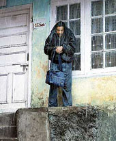 A man takes shelter in a verandah as rain lashed Shimla.