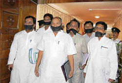 Opposition members enter the Uttarakhand Vidhan Sabha with mouths tied with black clothes in protest against the Universities Bill in Dehra Dun on Friday.
