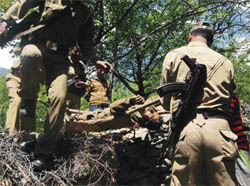 Policemen carry the body of one of the militants in Lurgam-Tral village, 45 km from Srinagar, on Saturday.