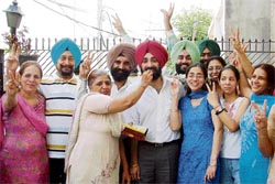 Family members of Ravneet Singh offer sweets to him on his success in the Civil Services examination