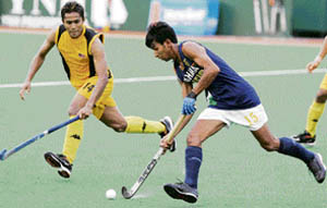 Vivek (R) controls the ball chased by Azlan Misron from Malaysia during a match at the 17th Sultan Azlan Shah Cup field hockey tournament on Saturday. 