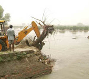 JCB machine being used to plug the breach and save the main road after a breach in the Kikkarkhera sub-canal near Abohar town on Sunday. 