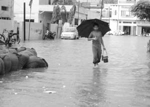 A boy walks in a flooded street after thundershowers in Fatehgarh Sahib on Monday. 