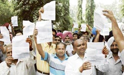 Government employees stage a protest after the venue of the forthcoming panchayat poll election was changed from Rotary Bhawan in Ludhiana to Pakhowal village