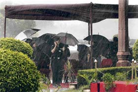 Army soldiers take cover from rain while waiting for the German Army Chief, Lt-Gen Hans Otto Budde, to inspect the Guard of Honour at South Block in New Delhi