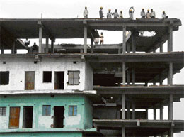 The municipal corporation workers demolish a portion of an unsafe five-storey building in Kajheri village in Chandigarh on Tuesday.