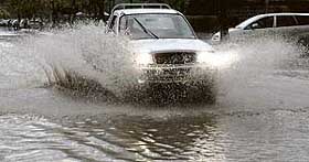 A car splashes through water after rain inundated Punjabi University roads in Patiala on Tuesday. 