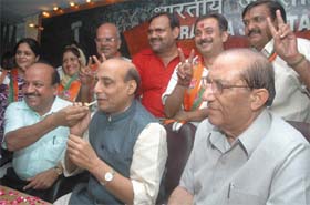 Delhi BJP president Harsh Vardhan offers sweets to party president Rajnath Singh in the presence of Vijay Kumar Malhotra and winners of the Delhi Cantt Board polls in New Delhi