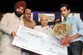 Chief Minister Sheila Dikshit presents a cheque of Rs 10 lakh to Delhi cricketer Gautam Gambhir in New Delhi