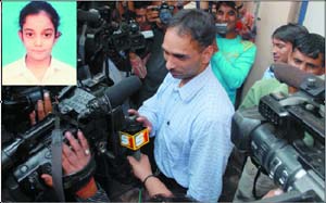 Inspector Jitender Kumar speaks to the media outside the residence of Dr Rajesh Talwar whose daughter, Arushi (inset), was murdered recently.