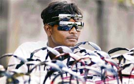 A vendor braves the hot sun to make a living as he sells sunglasses by a roadside on the outskirts of Jammu on Wednesday.
