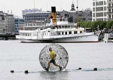 German artist Arnd Drossel walks in his Inner Balance device on Lake Leman in Geneva on Wednesday. Drossel will make a performance on May 23, as part of a side event of a meeting of local associations dealing with psychic health. 
