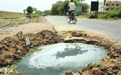 A potholed road between the elevated railway track and Sector 48 in Chandigarh. Tribune photo: Parvesh Chauhan