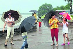 Children welcome rain at Sukhna Lake in Chandigarh on Thursday. 
