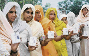 Voters show their voter ID cards during the bypoll at Garhi Gujran village in the Indri constituency in Karnal district on Thursday.