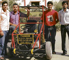 The achievers stand tall with their trophy vehicle.