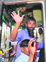 Freed Indian fishermen wave as they board a bus in Karachi on Friday.