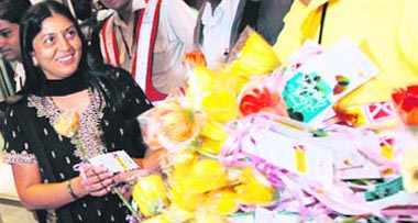 The first passenger to disembark Sheila Shenai (L) is greeted by flowers on her arrival from Mumbai at Bengaluru International Airport Limited (BIAL) at Devanahalli in Bangalore