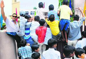 Children struggle to have a look at WWE wrestler Khali (inset) at a function organised by the National Integrated Forum of Artists and Activists in his honour at R.S. Public School in Karnal on Saturday.