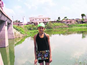 Baby Kumari (12) at the pond in her village, where she practices swimming