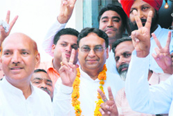 Congress candidate Bhim Sen Mehta shows the victory sign along with his supporters after winning the byelection from the Indri assembly constituency in Karnal on Sunday.
