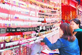 Girls have a look at various jewellery items on display at a craft exhibition at the Ridge in Shimla