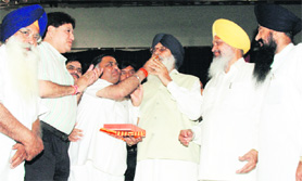 Industries minister Manoranjan Kalia offers sweets to CM Parkash Singh Badal after the party's victory in Amritsar bypoll, while tourism minister Hira Singh Gabria and SAD MP Sharanjit Singh Dhillon look on, in Ludhiana on Sunday.