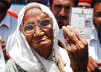 109-year-old Jasmel Kaur shows her photo I-card as she arrives at the polling booth in Bhai Roopa village on Monday.
