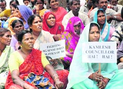 Members of the Chandigarh Municipal Corporation Employees Union raise slogans demanding to revoke junior engineer Balraj Singhs suspension outside the municipal corporation building in Sector 17, Chandigarh, on Monday.