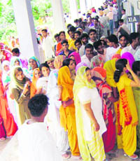Voters at a polling booth in GHG Khalsa Senior Secondary School, Bahadurgarh, near Ahmedgarh, on Monday.