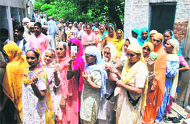 Women queue up at a polling booth at Mehraj village in Bathinda district on Monday.