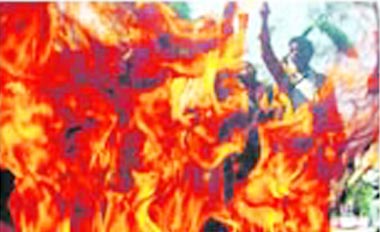 A group of students shout slogans after they burned tyres during a rally against the hike in fuel prices in Jakarta