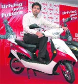Managing director of Hero Electric, Naveen Munjal, poses with the newly launched, battery-operated, MAXI in Bangalore
