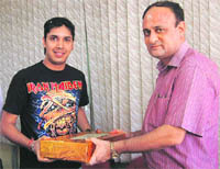 A winner of the Chandigarh Tribune Summer Tango receives a prize from The Tribune general manager Sanjay Hazari in Chandigarh on Tuesday. 