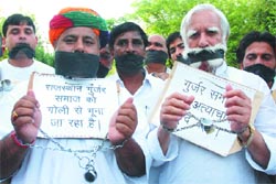 Gujjars cover their mouths with black cloth during a march from Rajghat to the Parliament House organised by the All-India Gujjar Sangarsh Samiti in New Delhi
