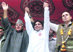 National Conference patron Farooq Abdullah and president Omar Abdullah raising hands of the party candidate at an election rally at Walarhana in Pahalgam