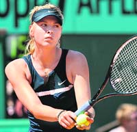 Russias Maria Sharapova serves to her compatriot Evgeniya Rodina during their French Open first round match at Roland Garros, on Wednesday in Paris. Sharapova won 6-1, 3-6, 8-6.